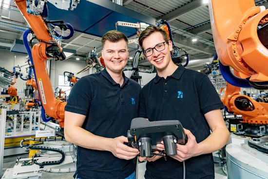 Two dual students work on a body-in-white production system.