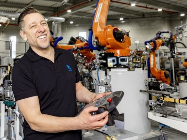 A employee of the EBZ Group programs an industrial robot.