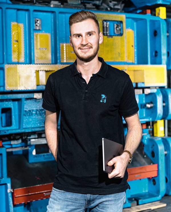 A dual student stands in front of an EBZ Group tool.