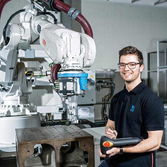 A dual student in the field of electrical engineering automation works on robotics and control technology.